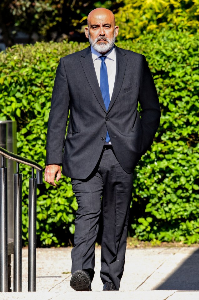 a man in a suit and tie walks down a sidewalk