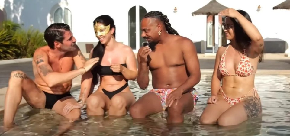 a group of people sitting in a pool with one wearing a mask