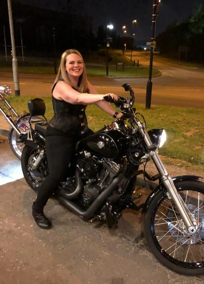 a woman is sitting on a black harley davidson motorcycle