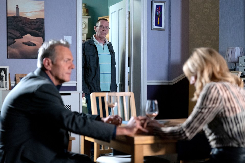 two men and a woman sit at a table with glasses of wine