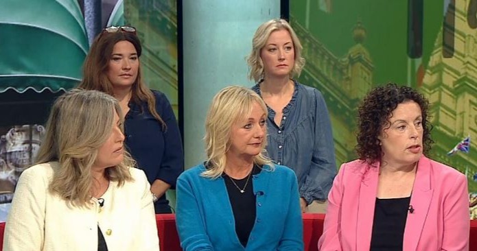 a group of women are sitting on a couch on a television show .
