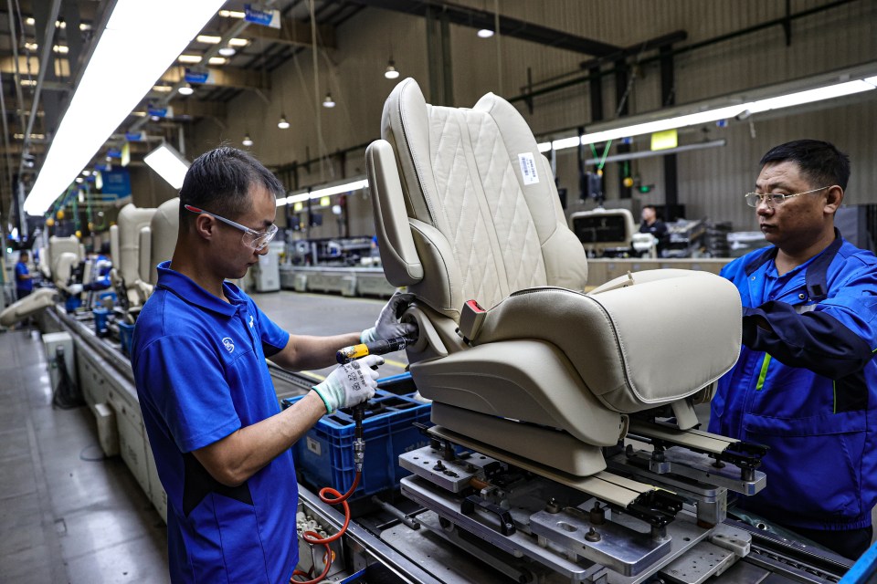 a man in a blue shirt is working on a car seat