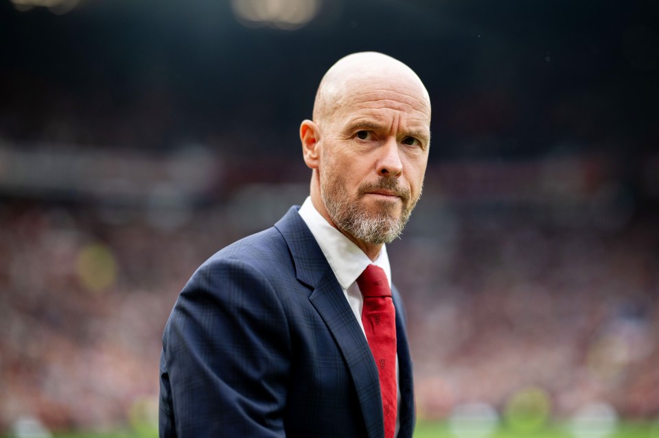 a bald man with a beard wearing a suit and red tie