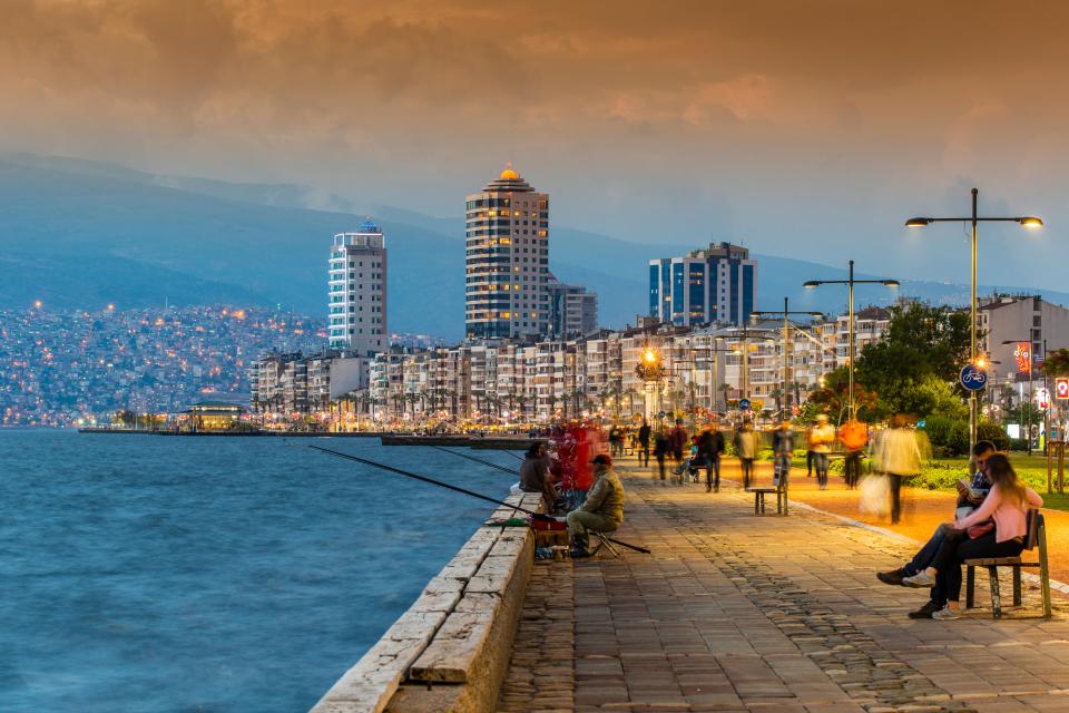 a man is fishing while a woman sits on a bench