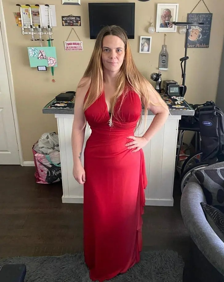 a woman in a red dress stands in front of a wall with a sign that says " take a hike "