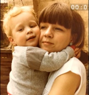 a woman is holding a child in her arms and the time is 00 : 01