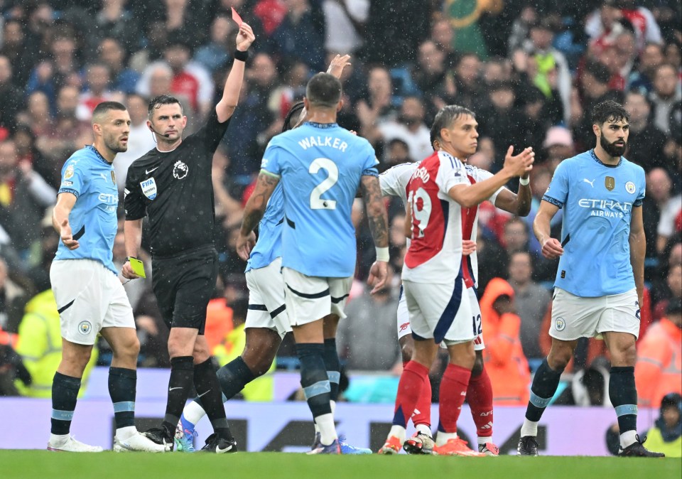 a referee shows a red card to walker during a soccer game