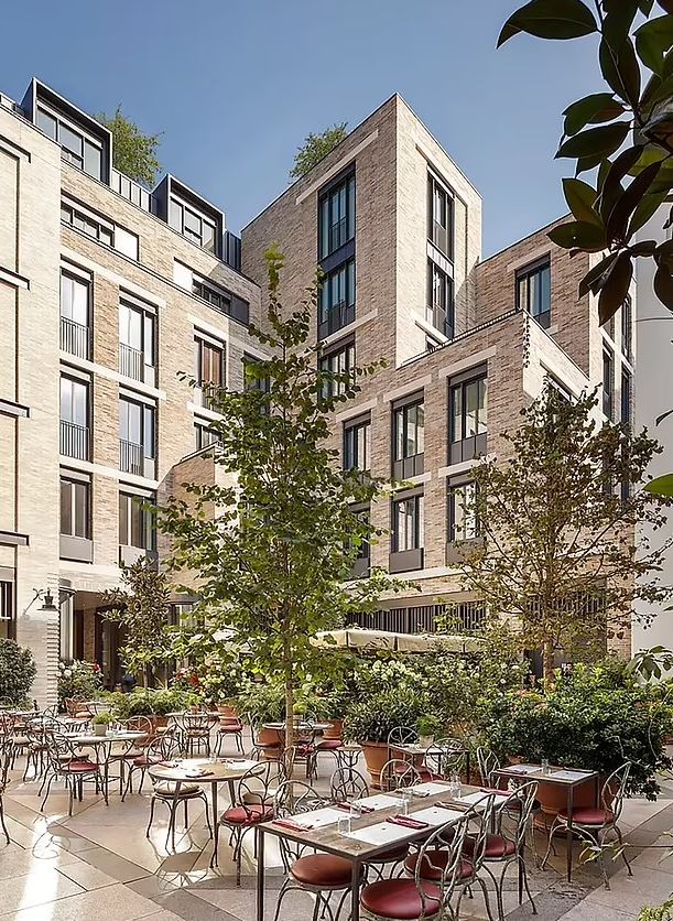 a brick building with tables and chairs in front of it