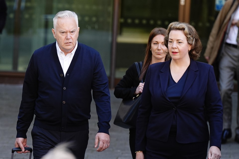 a man in a blue cardigan is walking with two women