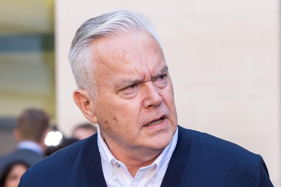 a man with gray hair is wearing a blue jacket and white shirt