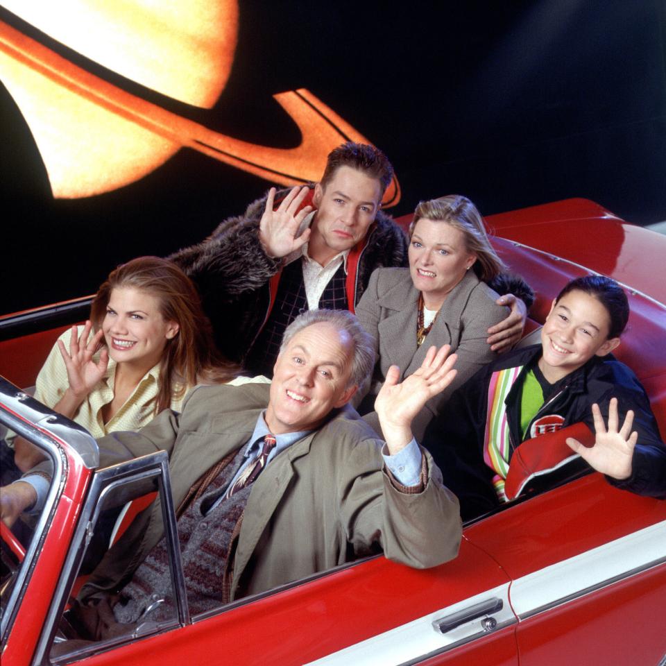 a group of people are sitting in a red car