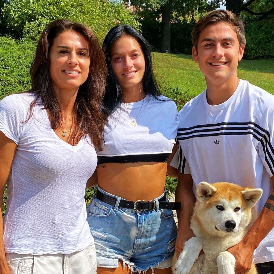 a man wearing an adidas shirt stands between two women and a dog