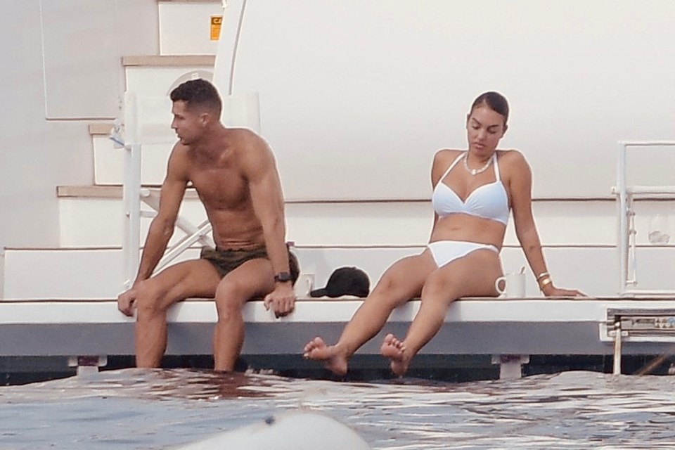 a man and a woman are sitting on a bench in the water