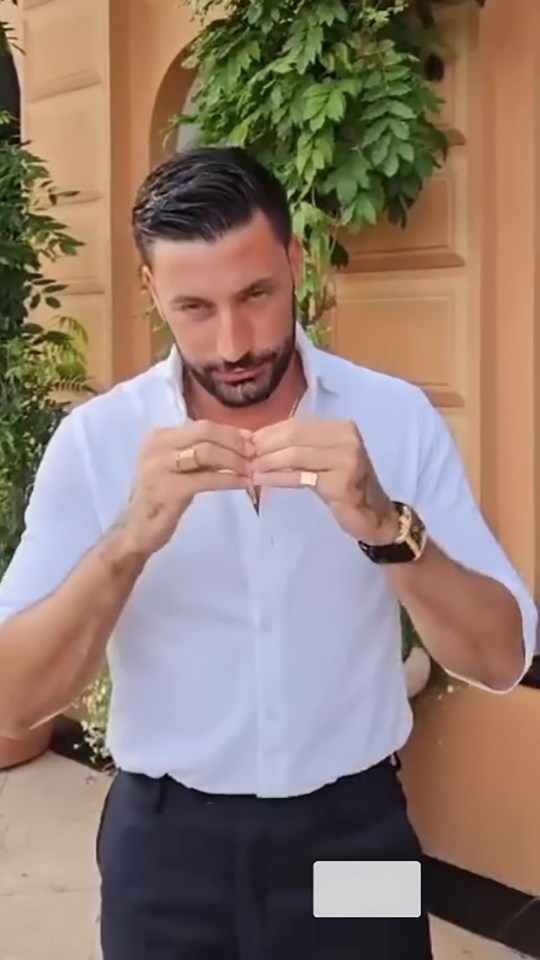 a man with a beard is wearing a white shirt and black pants