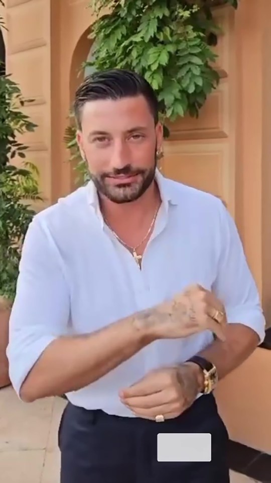 a man with a beard is wearing a white shirt and black pants