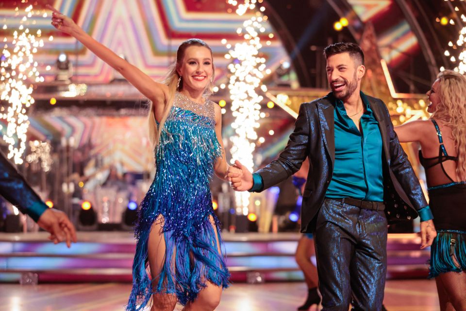 a man and a woman are holding hands on a dance floor