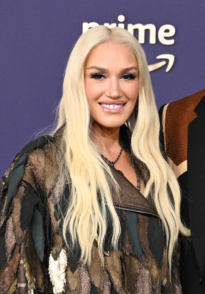 a woman with blonde hair is smiling in front of a sign that says prime