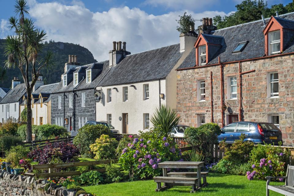a row of houses with a blue car parked in front
