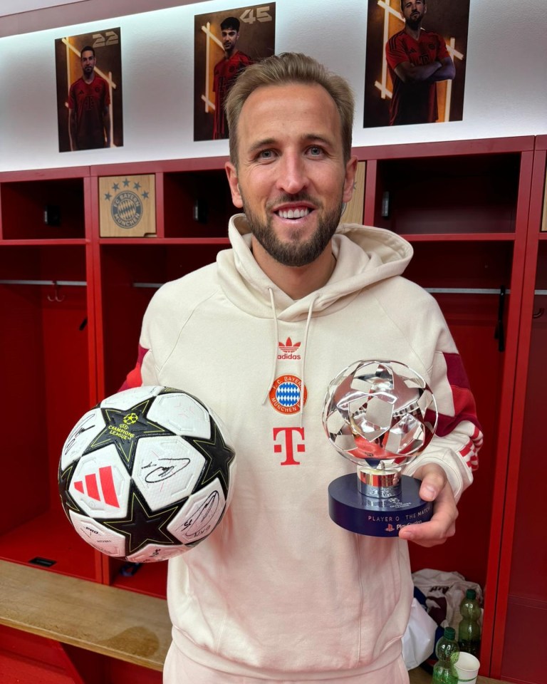 a man holding a trophy and a soccer ball in a locker room