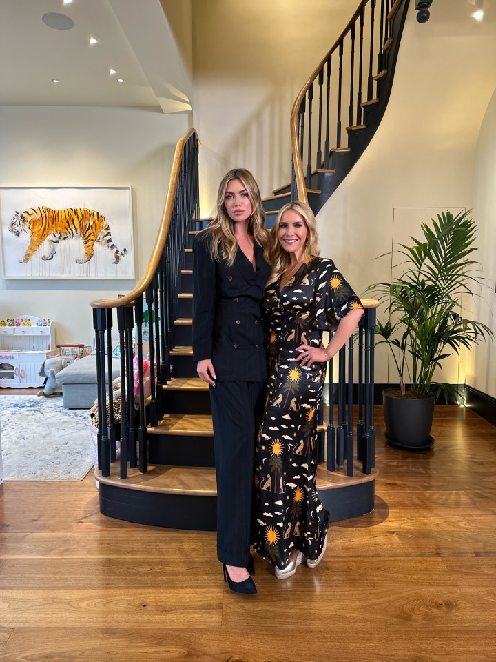 two women standing in front of a spiral staircase