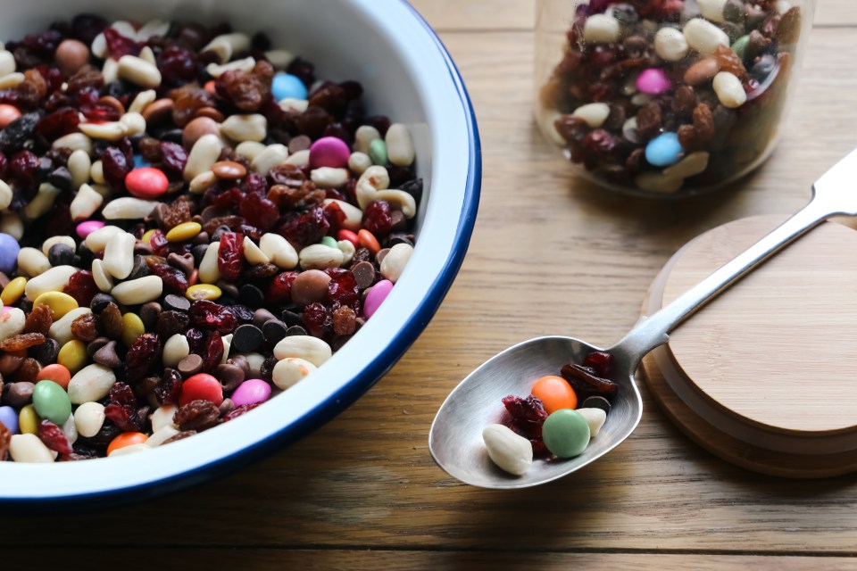 a bowl of nuts and candy next to a spoon