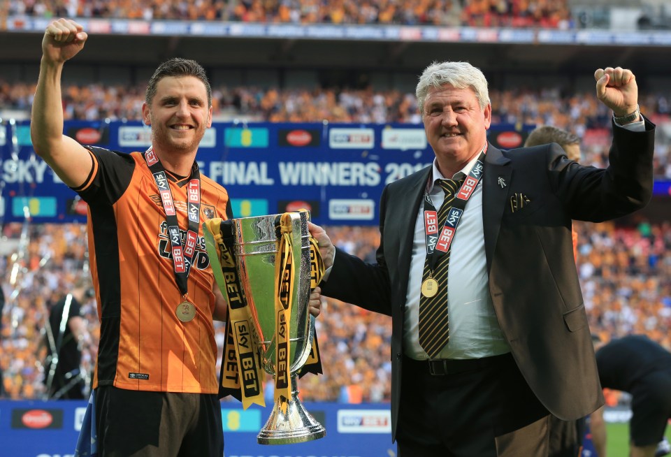 a man in a sky bet shirt holds a trophy next to a man in a suit