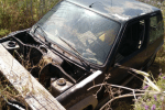 a black car is sitting in the grass with the hood open