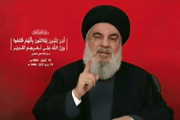 a man with a beard is giving a speech in arabic