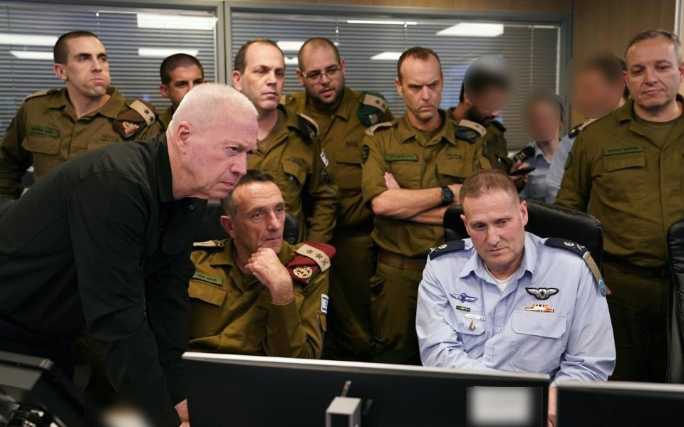 a group of men in military uniforms are looking at a computer screen