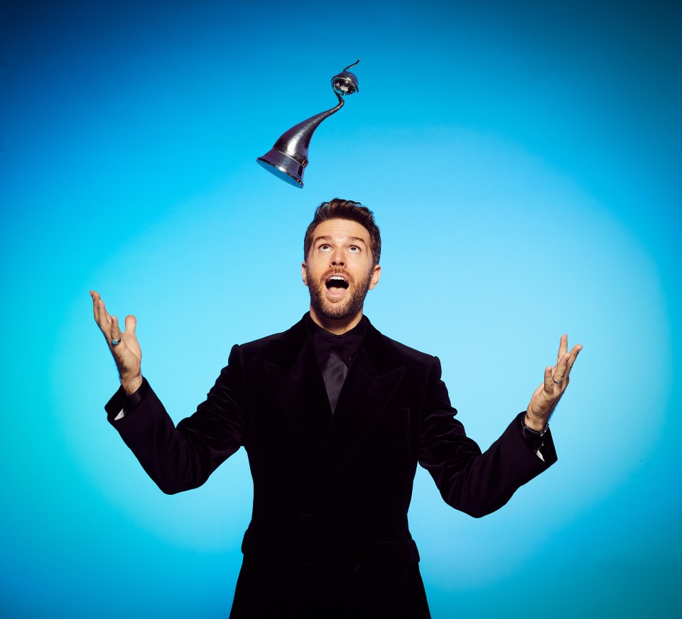 a man in a suit is throwing a trophy in the air