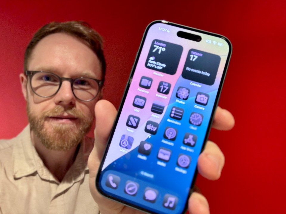 a man is holding a phone that says london 71 degrees
