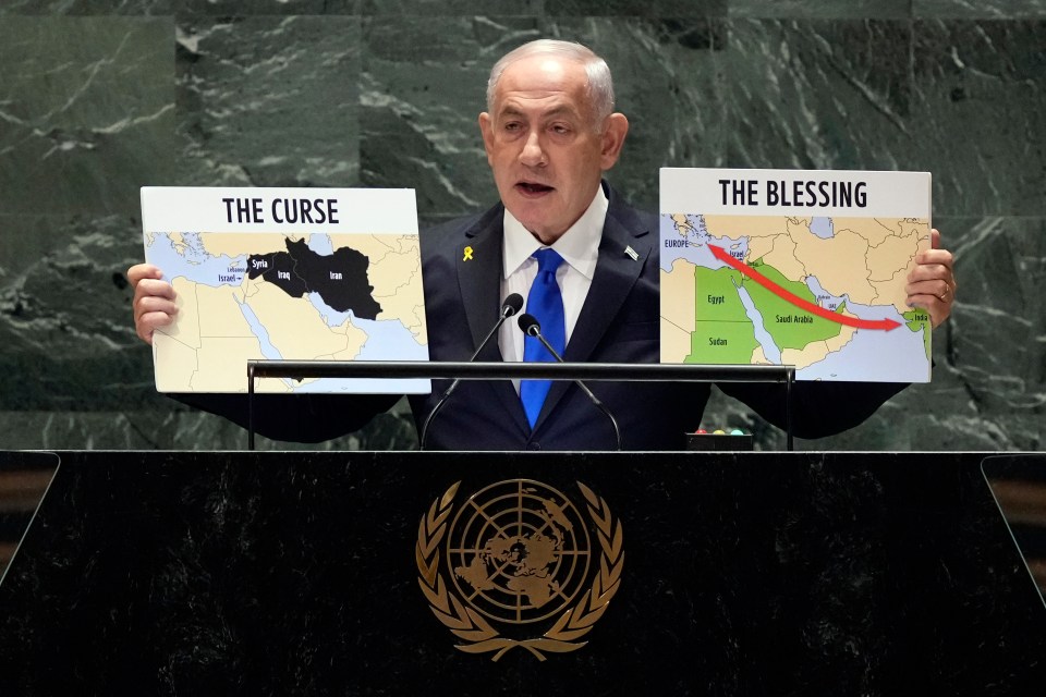 a man at a podium holding a sign that says the curse and the blessing