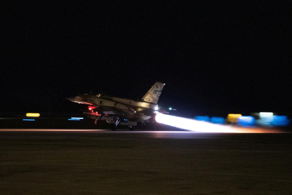 a fighter jet is taking off from a runway at night