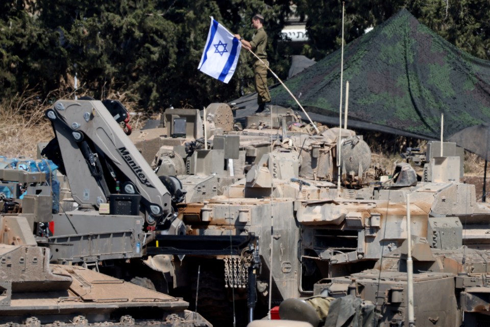 a man holding a flag in front of a manitou crane