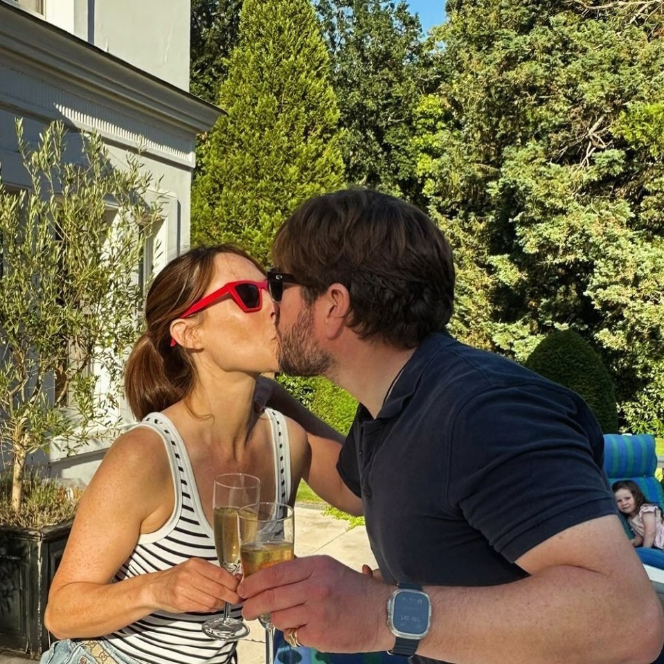 a man and woman kissing while holding glasses of champagne