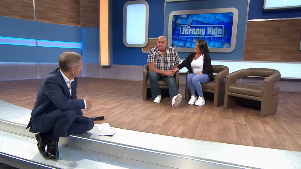 a man and woman are sitting on a stage in front of a sign that says jeremy kyle