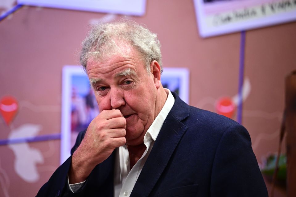 a man in a suit covering his nose with his hand