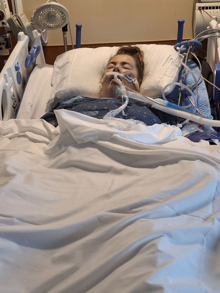 a woman is laying in a hospital bed with an oxygen mask on her face