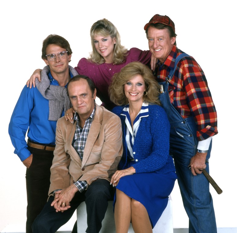 a group of people posing for a picture with one wearing overalls