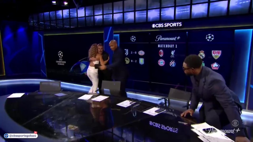 a cbs sports studio with a woman hugging a man