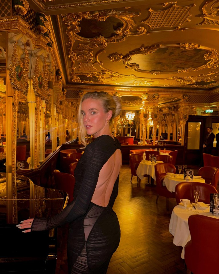 a woman in a black dress is standing in a restaurant