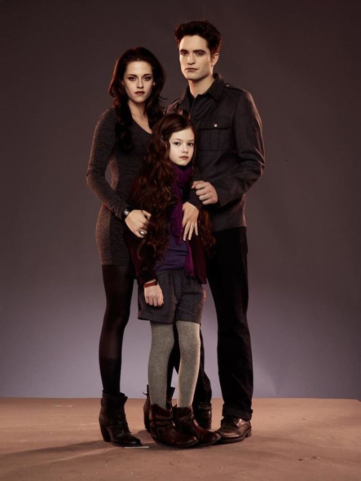 a man and woman standing next to a little girl