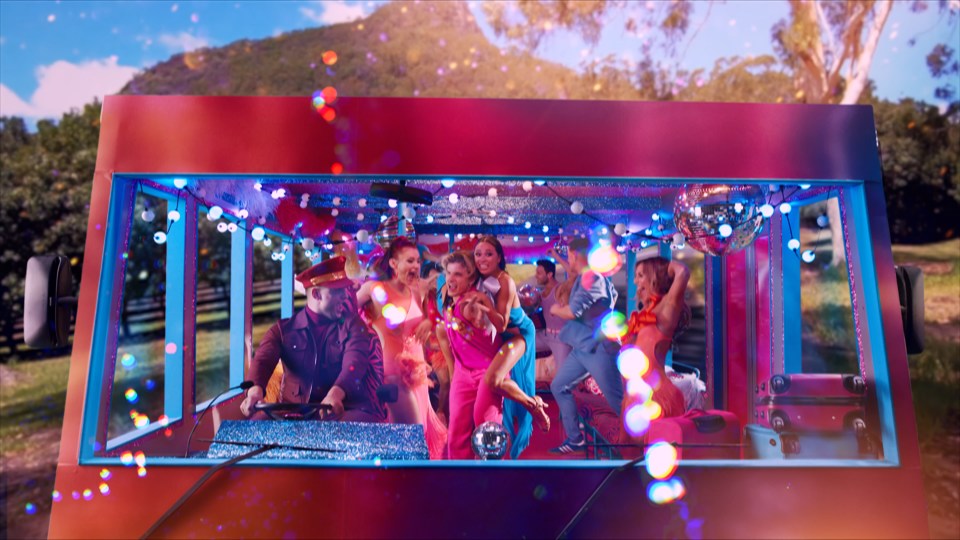 a group of people are dancing in a colorful vehicle