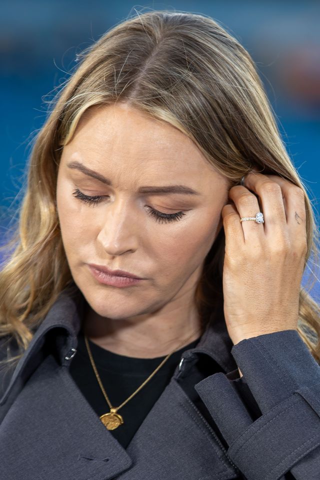 a woman with a ring on her finger looks down