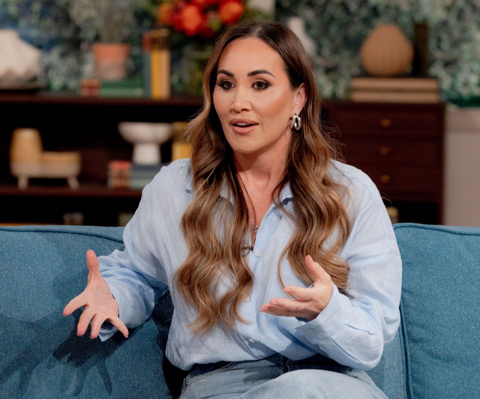 a woman sitting on a blue couch with her hands outstretched