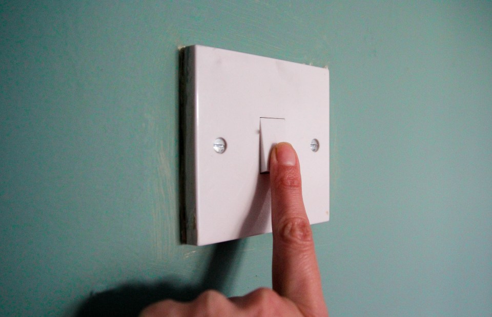 a person is pressing a light switch with their finger