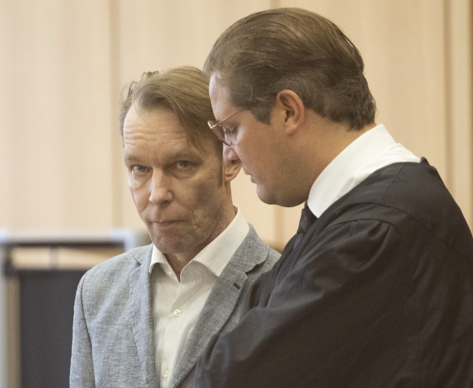 a man in a suit talks to another man in a white shirt