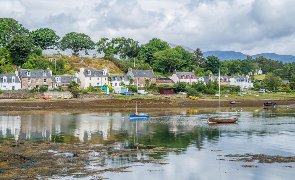 a row of houses sit on a hill overlooking a body of water