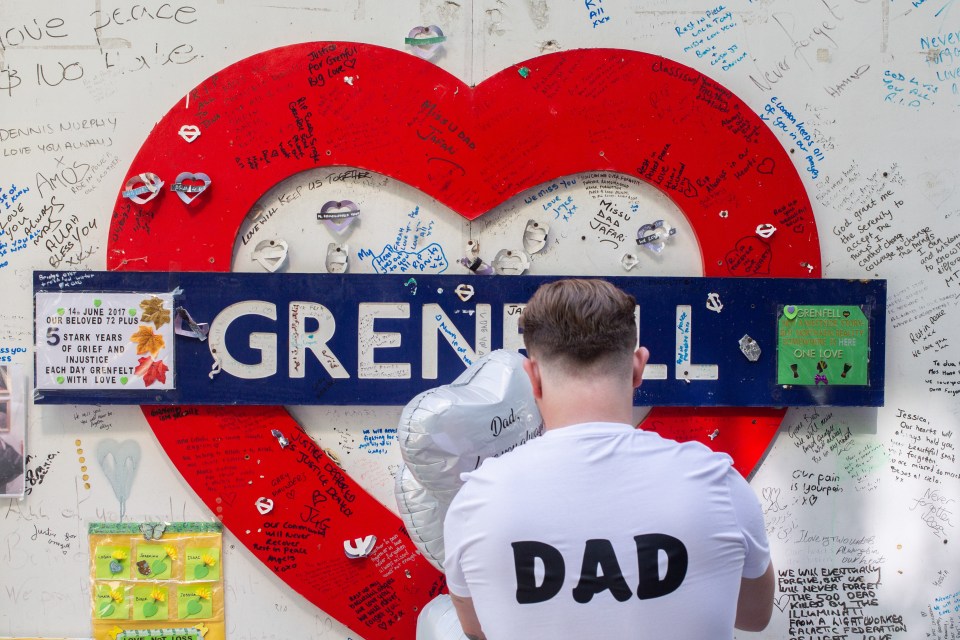 a man sitting in front of a heart shaped sign that says grenfell