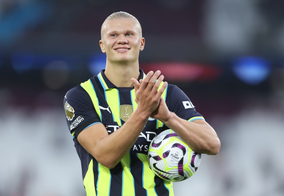 a man in a yellow and black striped shirt holds a soccer ball